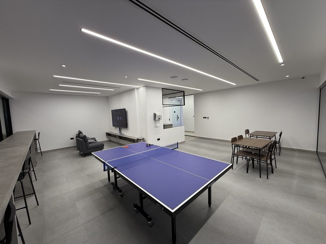Lounge with a table tennis table, seating and a TV