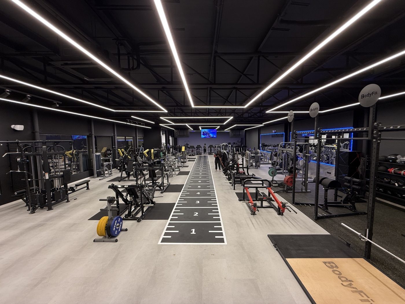 The mixed gym floor with a sprint track, power racks and machines