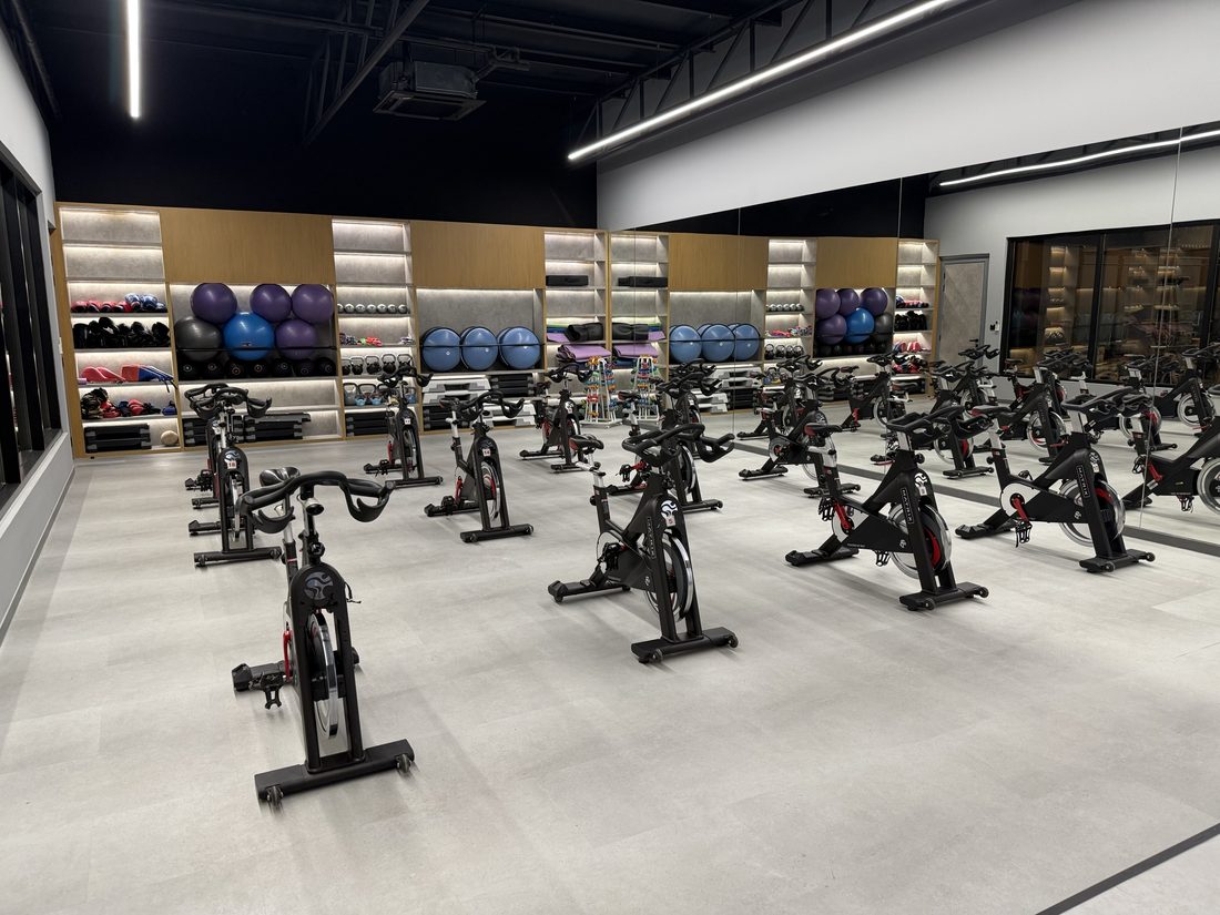 The spin studio with rows of indoor cycling bikes facing a mirror